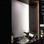 We made sure this custom glass wine room had table space where the owner could pour his wine safely and conveniently. Eventually, he can add a hanging, inverted stemware rack above.