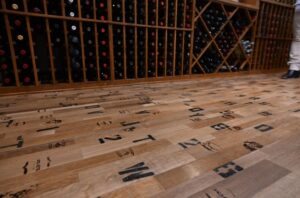 10 - Custom Wine Racks and Cooperage Flooring Create Rustic Elegance Custom wine racks paired with cooperage flooring in luxury Tarrytown wine room.