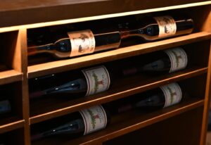 11 - Custom wine racks with LED lighting in upscale Austin wine room. Backlit panels softly highlight the grains and grooves of these hand-crafted wine racks.